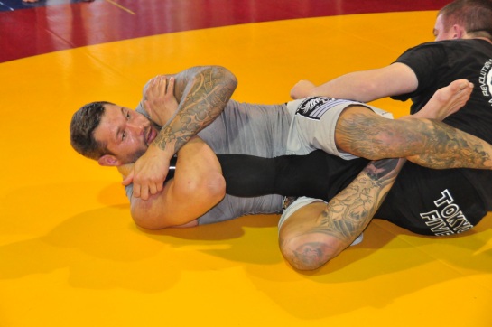 An MMA fighter holds another in a knee bar submission